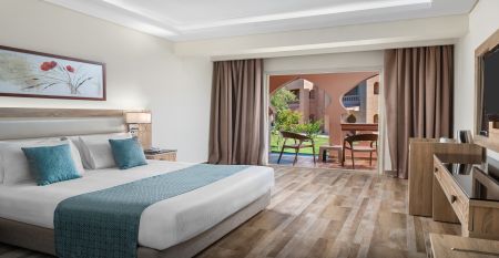 Aqua Vista Resort offers multiple outdoor pools, sun loungers, and umbrellas beneath clear blue skies—perfect for ein erfolgreiches Trainingslager in den Wintermonaten—with buildings and the sea in the background.