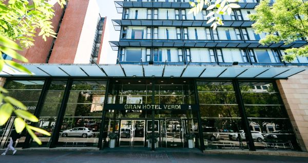 Außenansicht des Gran Hotel Verdi mit moderner Glasfassade und urbaner Umgebung.