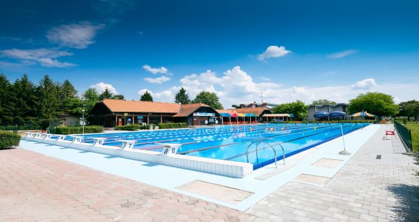 Ein moderner Außenpool mit klaren Bahnen, perfekt für Trainingseinheiten, mit umliegenden Sonnenschirmen.