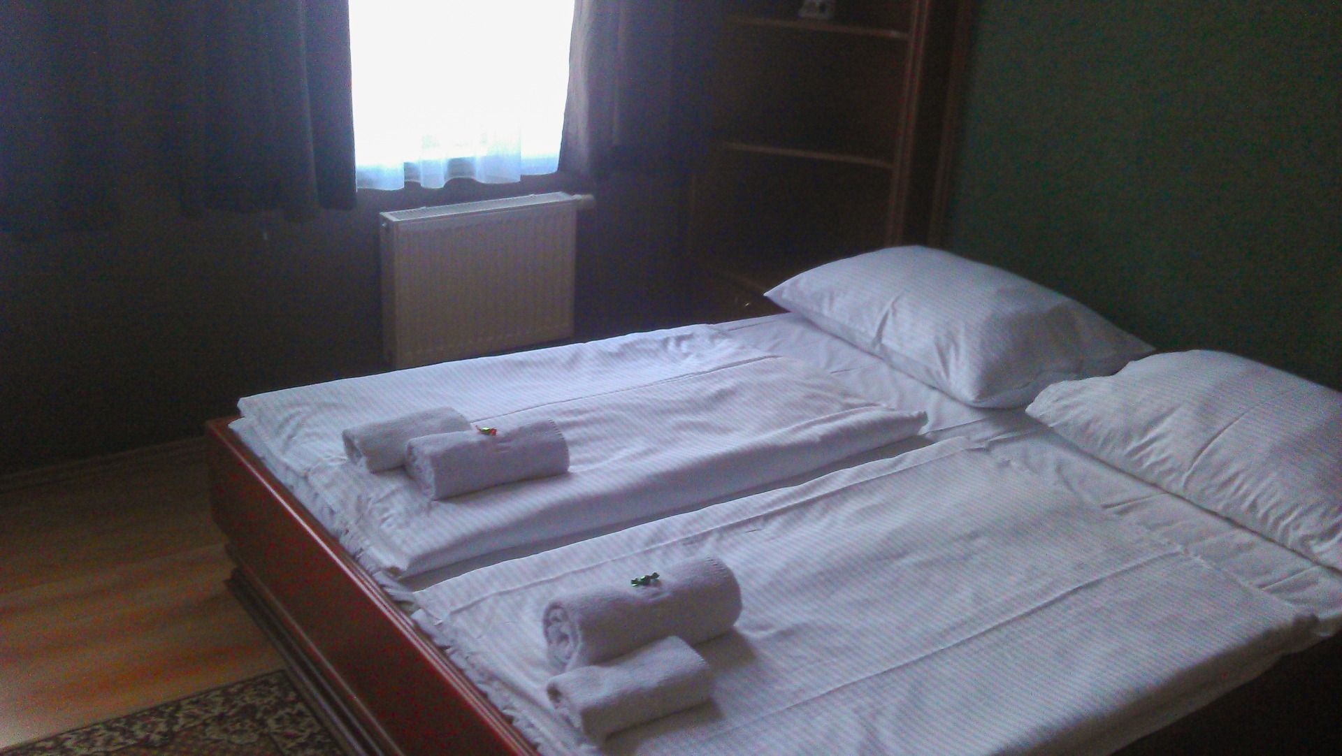 Gästezimmer im Hotel Goldener Hecht, ausgestattet mit Doppelbett, Holzmöbeln und einem Fenster mit Tageslicht.