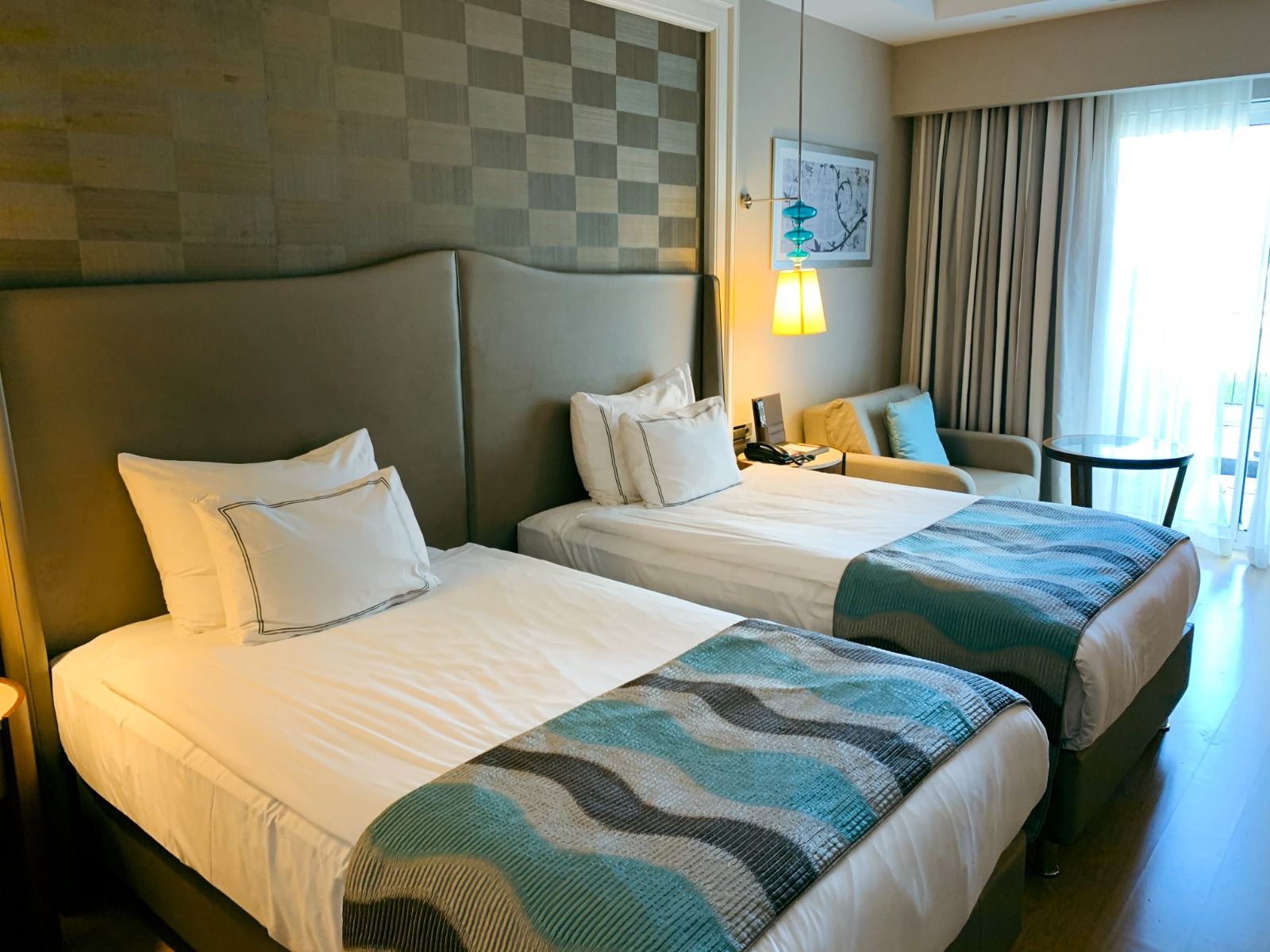 Luxuriöses Zimmer mit Zweieinzelbetten im Titanic Deluxe Hotel mit modernen Möbeln und einem einladenden Ambiente.
