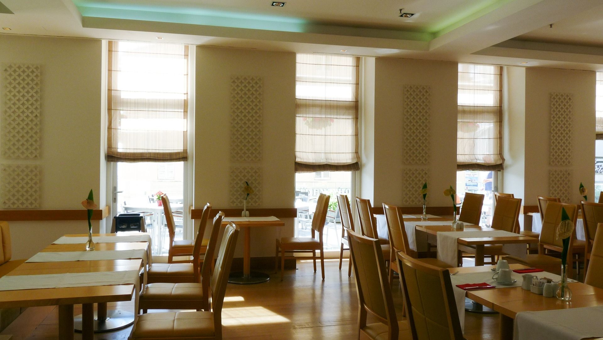 Helles Restaurant im Hotel Astoria mit großen Fenstern, modernen Tischen und gemütlicher Atmosphäre für Gäste