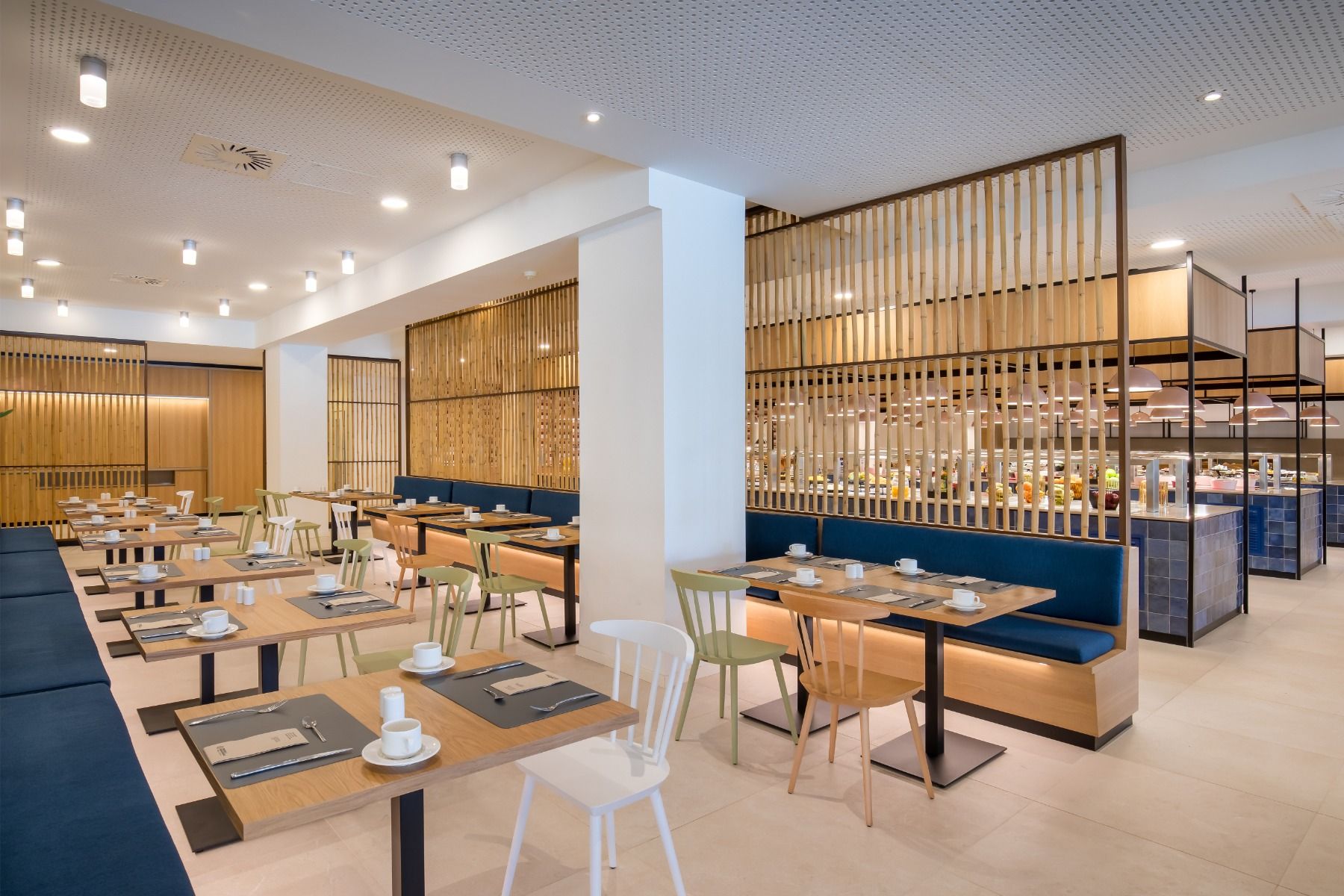 Essbereich mit modernen Holzmöbeln, heller Beleuchtung und offener Gestaltung im Restaurant.