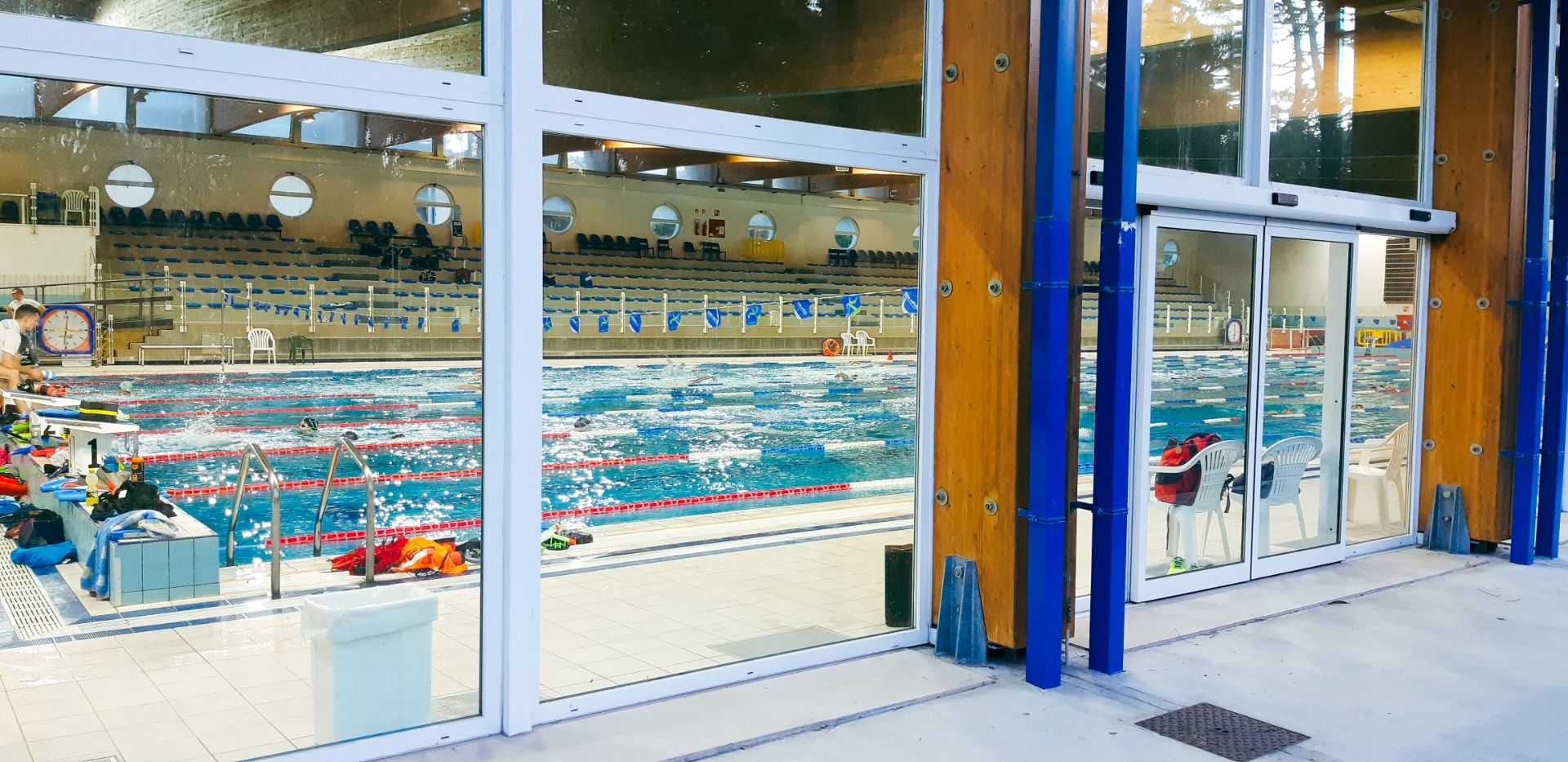 Innenansicht eines Hallenbads mit klaren Schwimmbahnen, großen Fenstern und moderner Architektur, geeignet für professionelles Schwimmen
