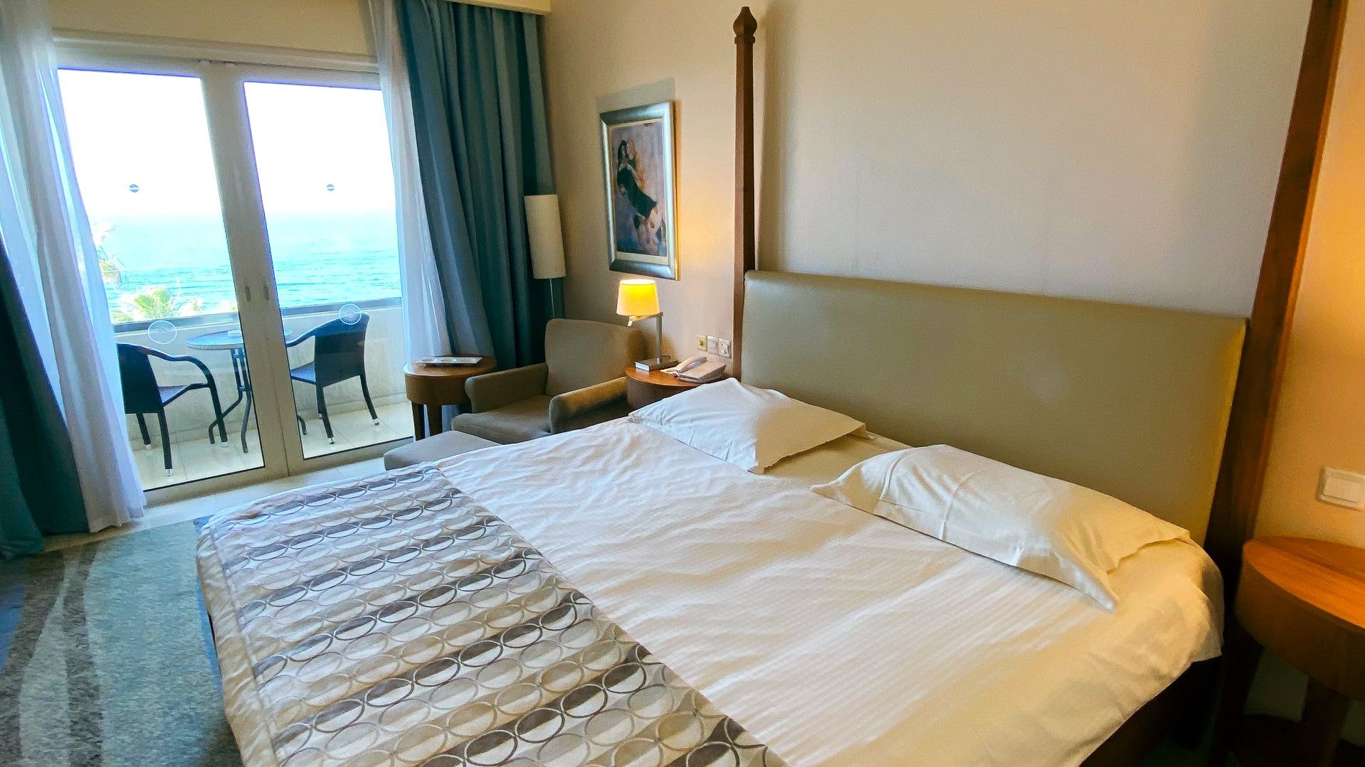 Luxuriöses Zimmer mit Balkon und Panoramablick auf das Meer, ausgestattet mit elegantem Mobiliar.