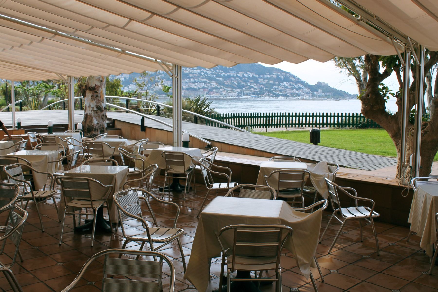 Terrasse des Hotels Coral Platja mit Blick auf das Meer und Sitzgelegenheiten.