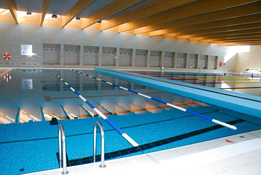 Heller Schwimmbadbereich mit einem Holzdach für eine gemütliche Atmosphäre.