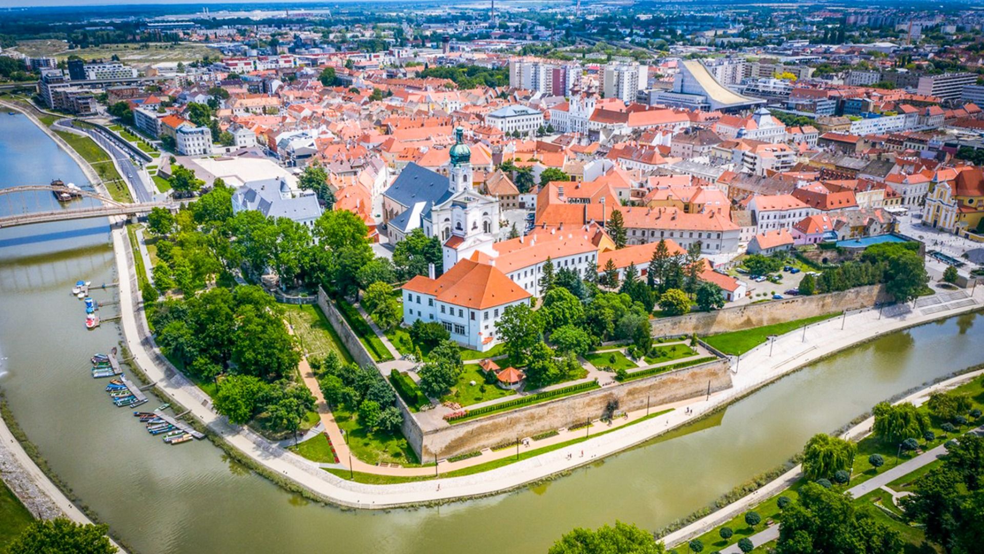 Luftaufnahme der historischen Stadt Győr in Ungarn mit roten Dächern, einer Flusslandschaft und grünen Parkanlagen