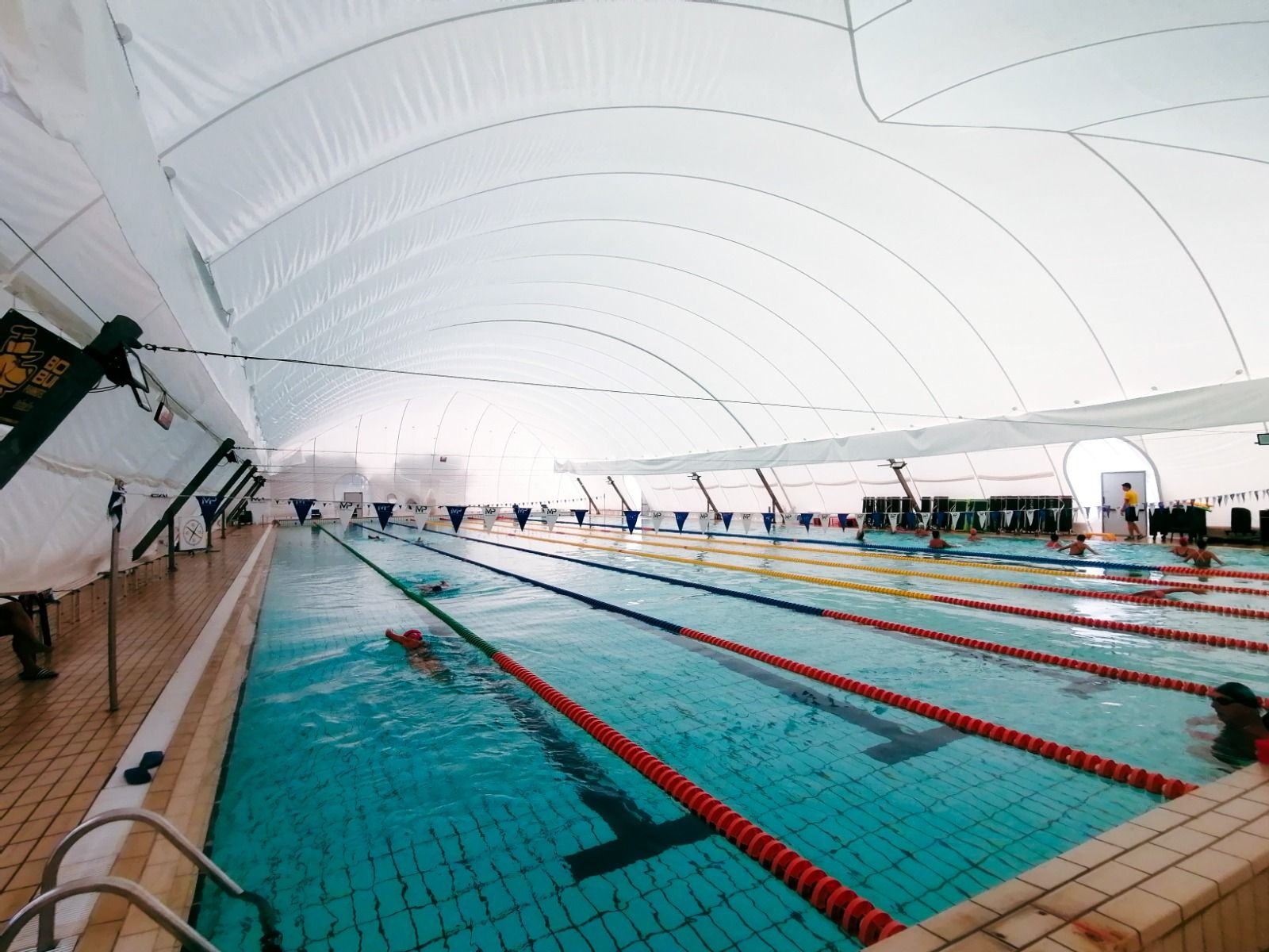 Großes, professionelles Schwimmbecken mit Traglufthalle und mehreren Bahnen für leistungsorientiertes Schwimmtraining