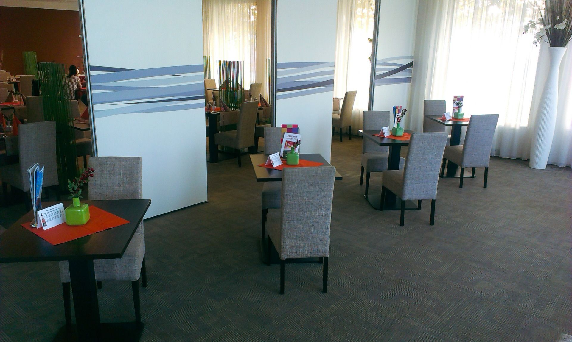 Moderne Einrichtung eines Restaurants mit minimalistischer Dekoration und großen Fenstern.