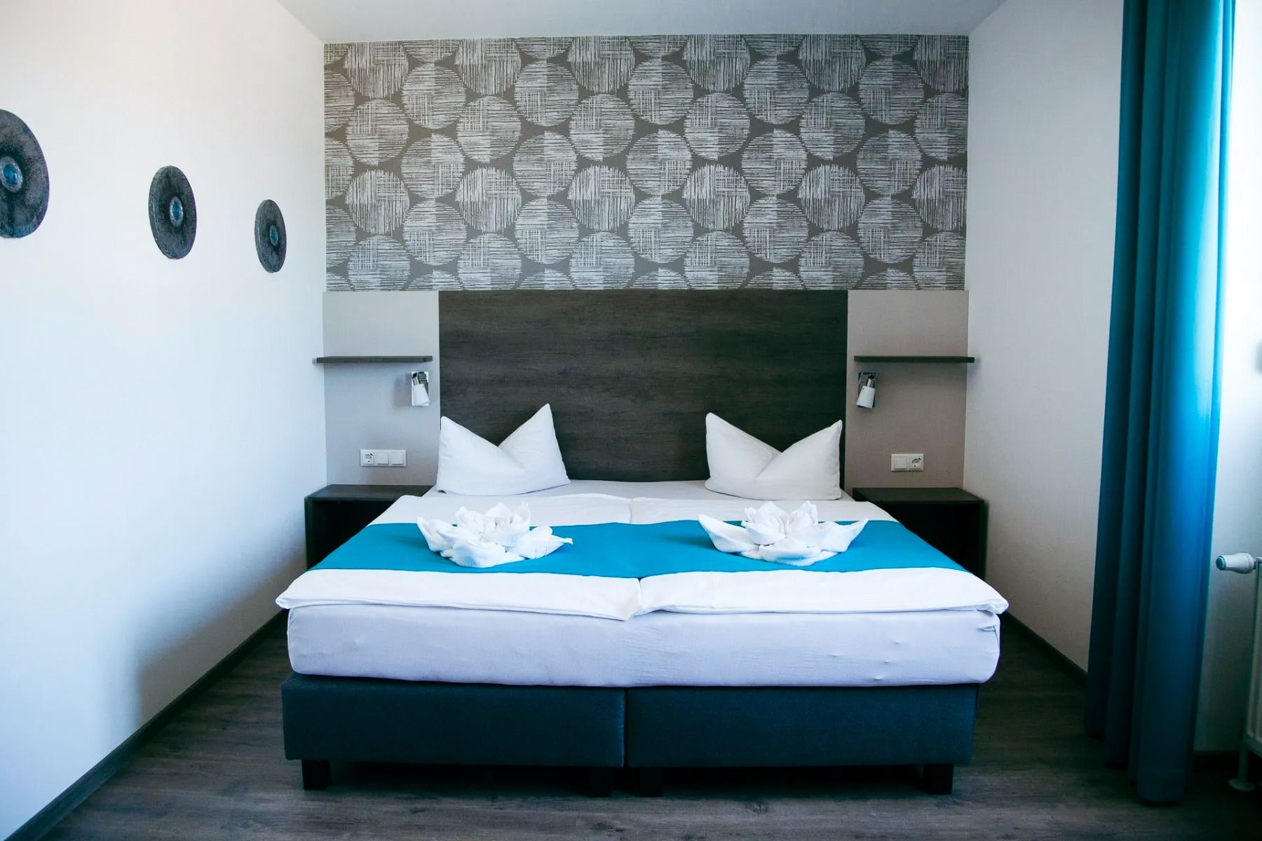 Doppelbett in hellem, modernen Zimmer im Hotel Kaiserpark