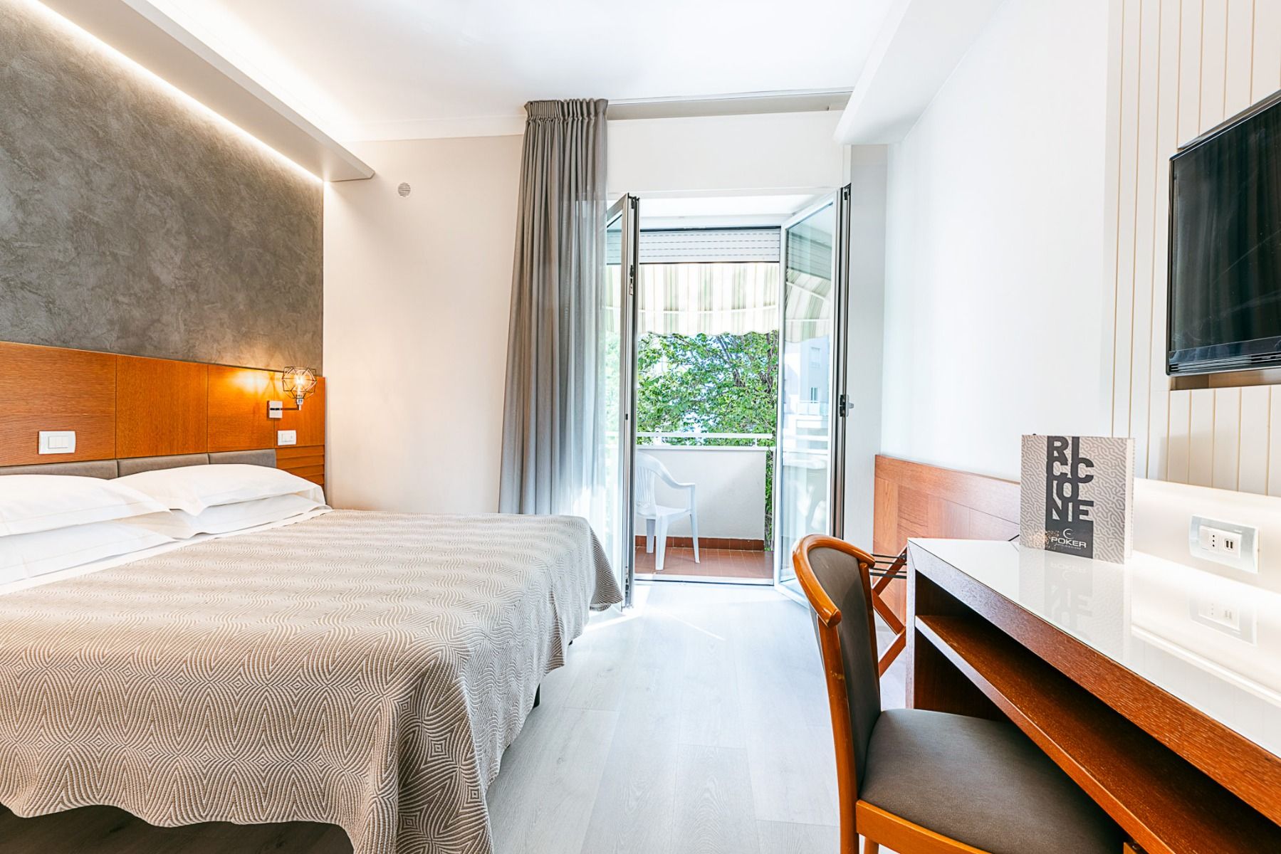 Doppelzimmer im Hotel Poker in Riccione, Italien, mit Balkon, modernem Mobiliar und gemütlicher Atmosphäre