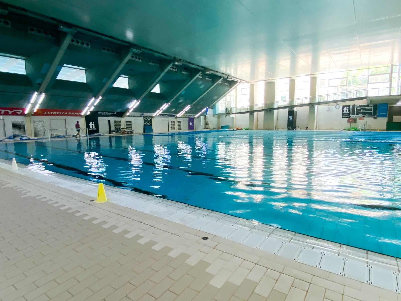 Hallenbad mit großen Fenstern, Schwimmbahnen und moderner Ausstattung für Sportler.