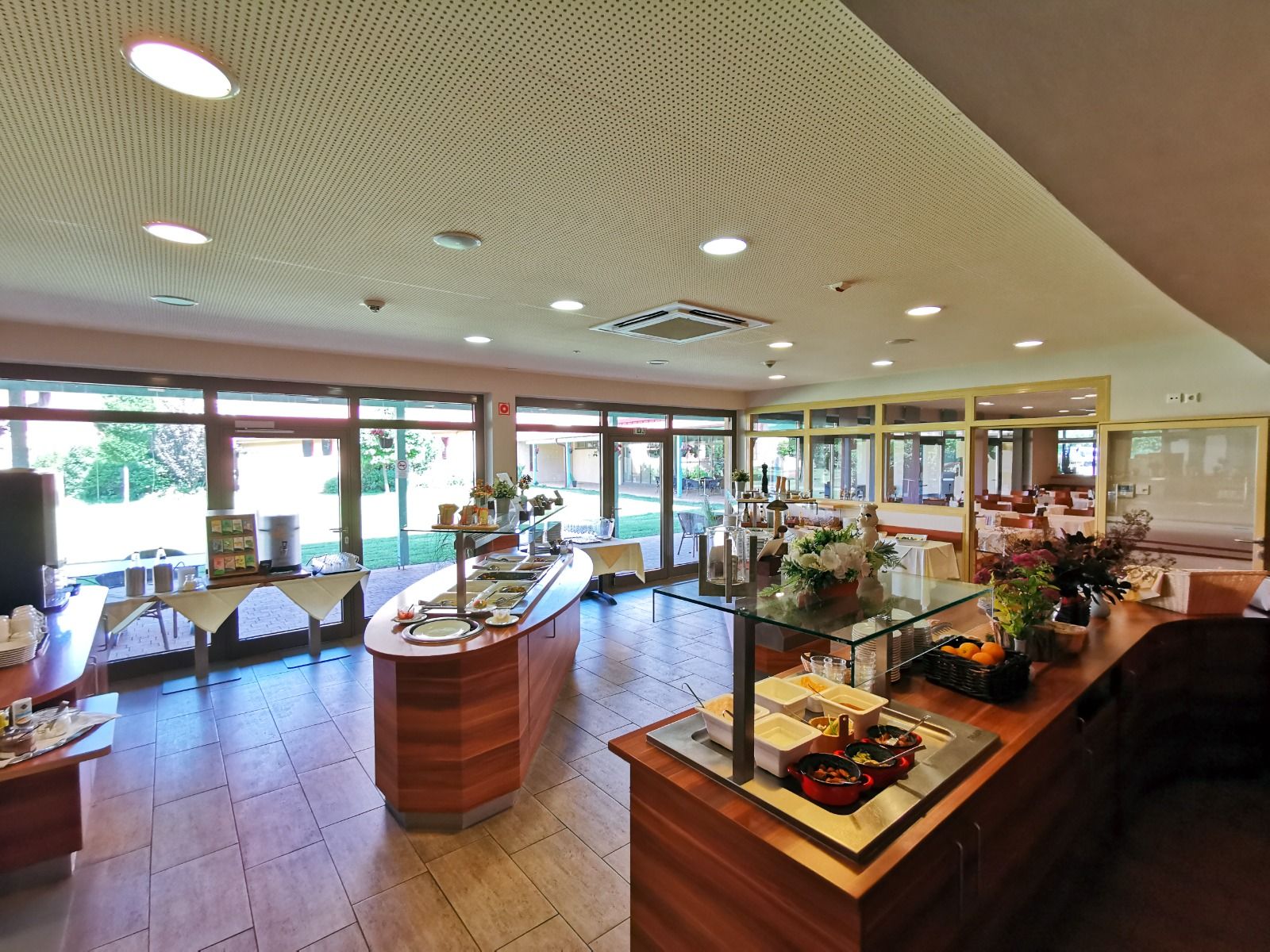 Ein moderner Speisesaal mit Selbstbedienungsbuffet, großen Fenstern und einer einladenden Atmosphäre.