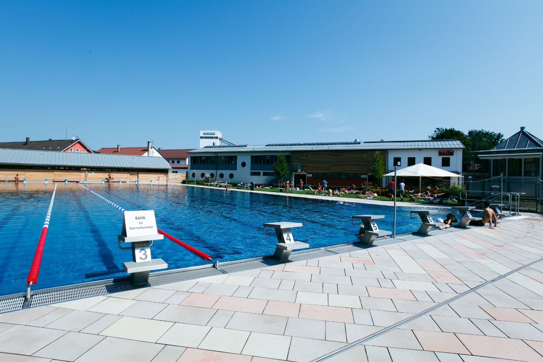Freibad Rosenheim mit Startblöcken und Sportschwimmbahnen mit blauem Himmel
