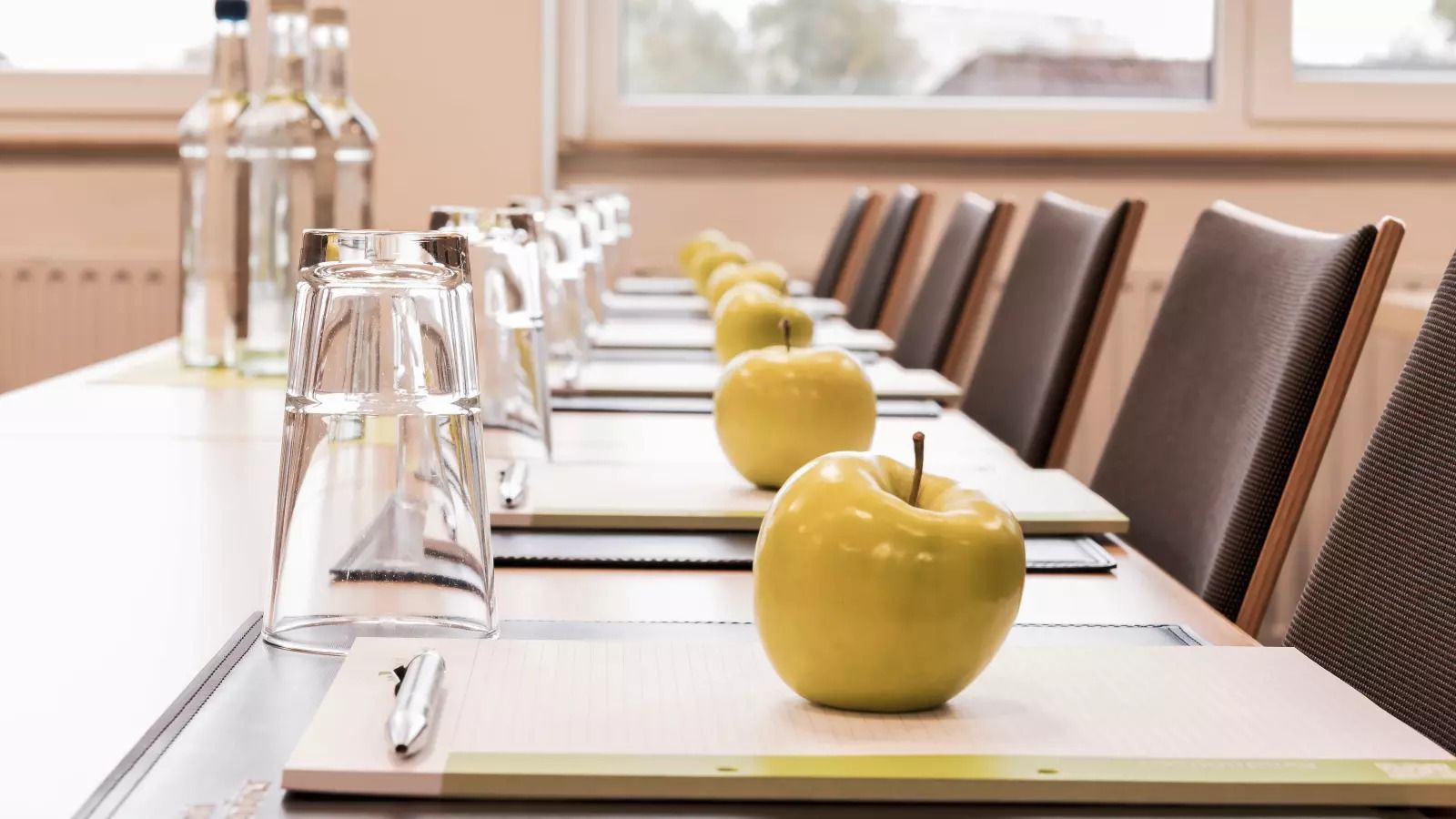 Gedeckter Tisch mit Gläsern und einem Apfel auf jedem Platz im Kiek In!