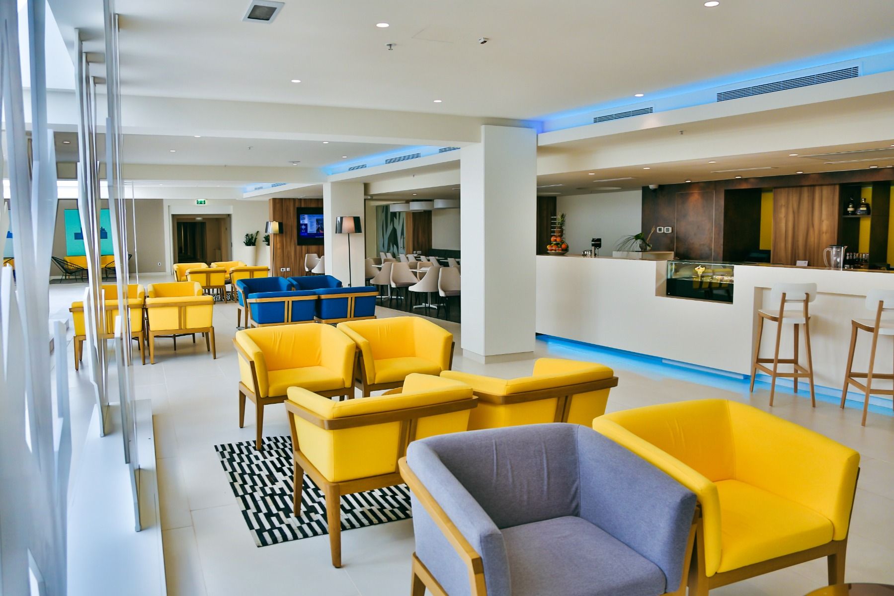 Geräumige, helle Lobby mit bunten Sesseln, modernem Design und einer gemütlichen Atmosphäre