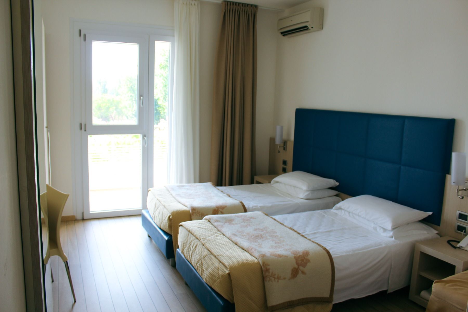 Standard-Doppelzimmer mit zwei enger stehenden Einzelbetten im Hotel Pra Delle Torri mit Zugang zum Balkon