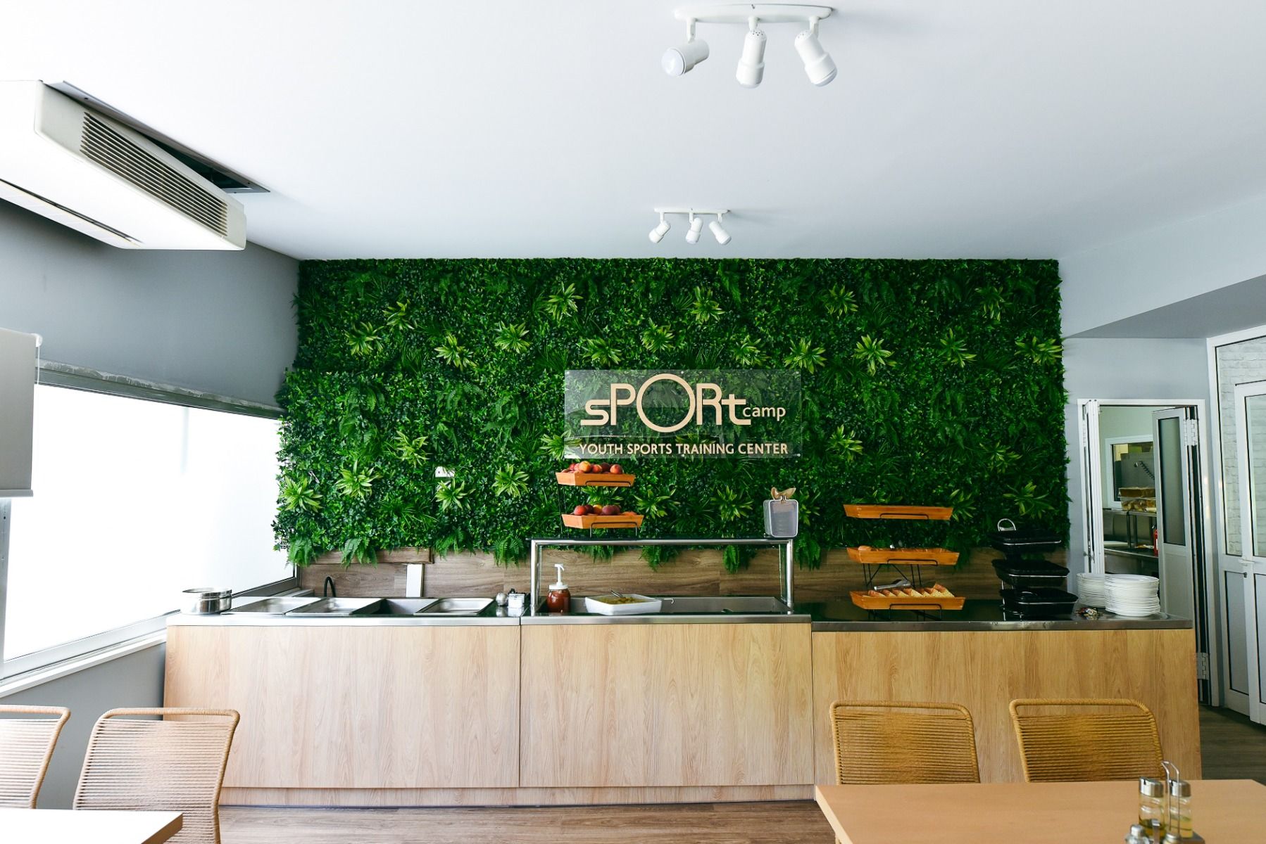 Buffet im Essensbereich mit ansprechender, künstlich bepflanzter Wand im Sport Camp Loutraki