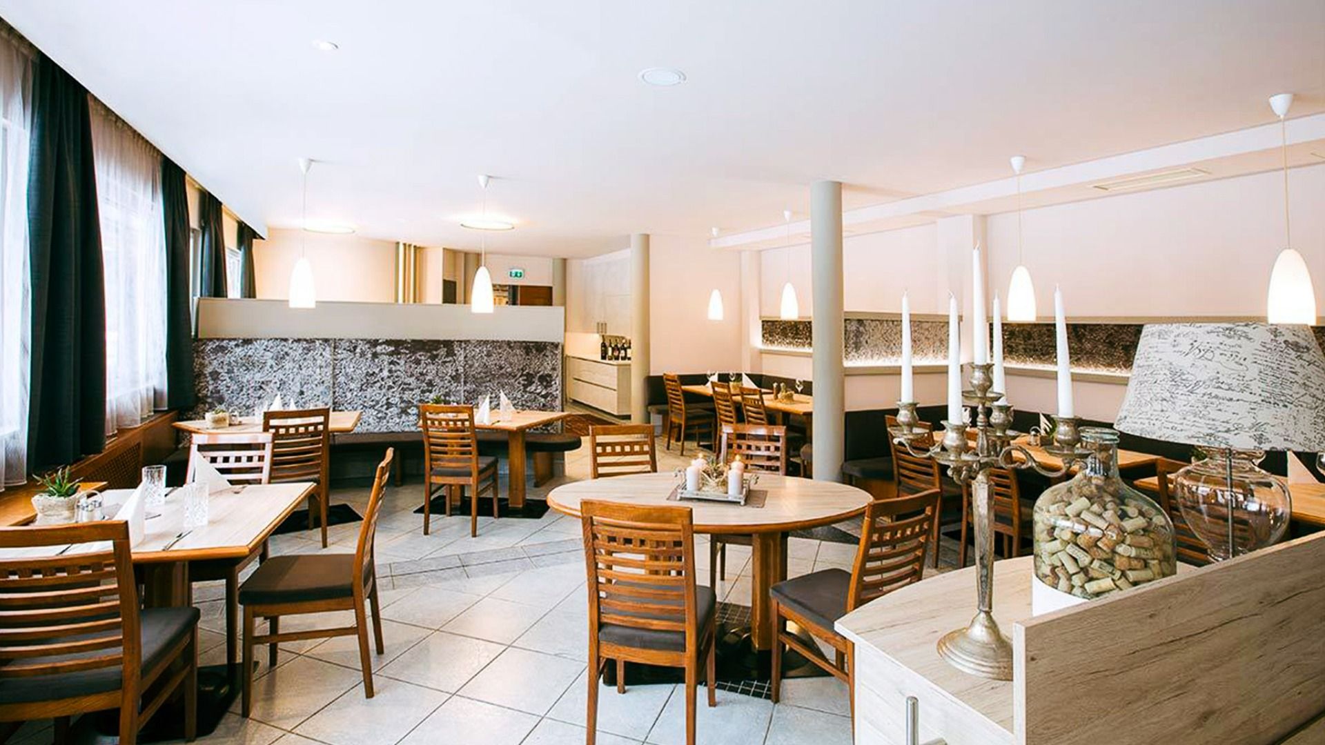 Gemütliches Hotelrestaurant im Sporthotel Kapfenberg mit Holzmöbeln, dekorativen Kerzen und stilvoller Atmosphäre