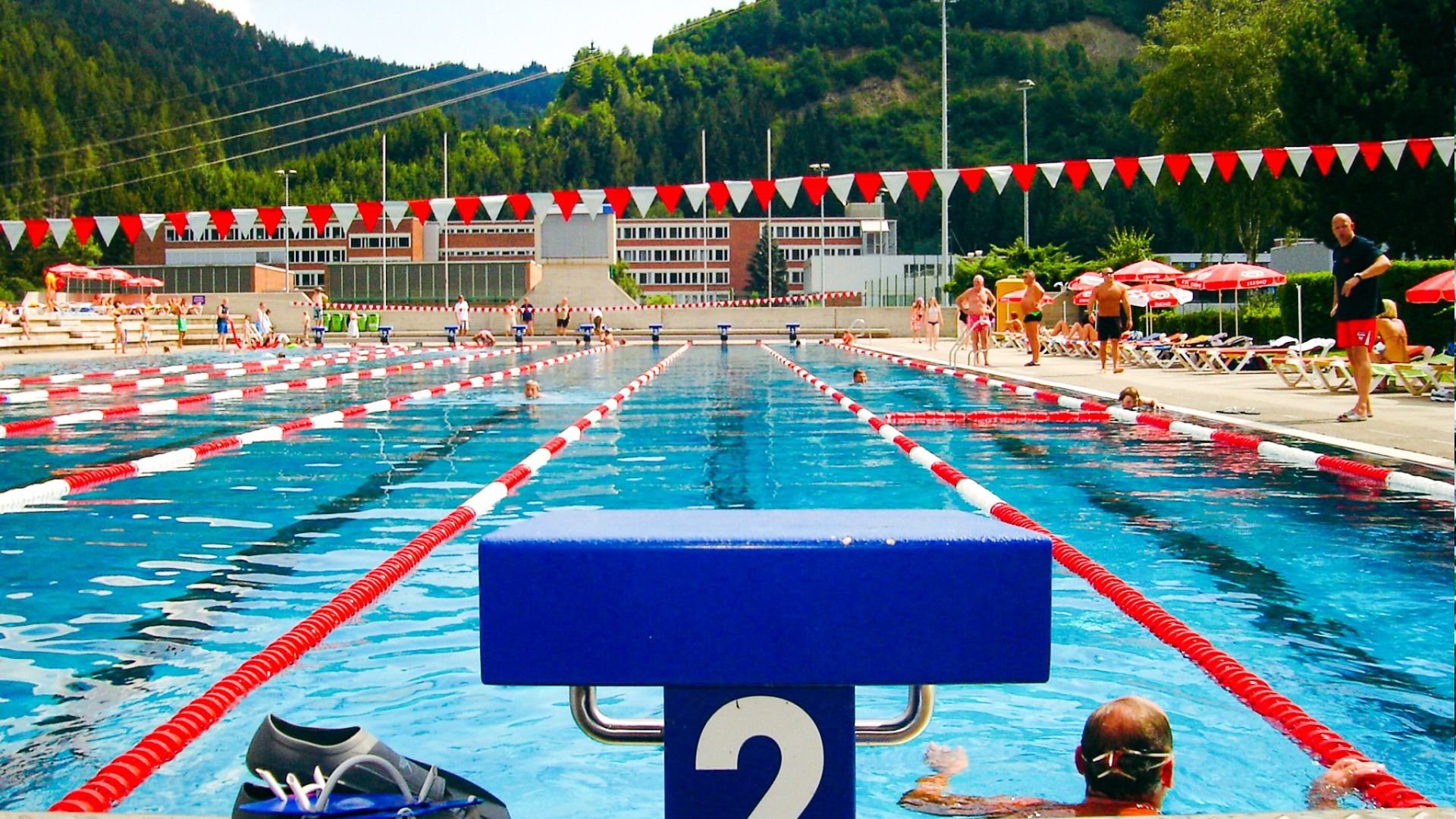 Blick auf das Wettkampfbecken im Sporthotel Kapfenberg, mit Startblock und roten sowie weißen Schwimmbahnmarkierungen