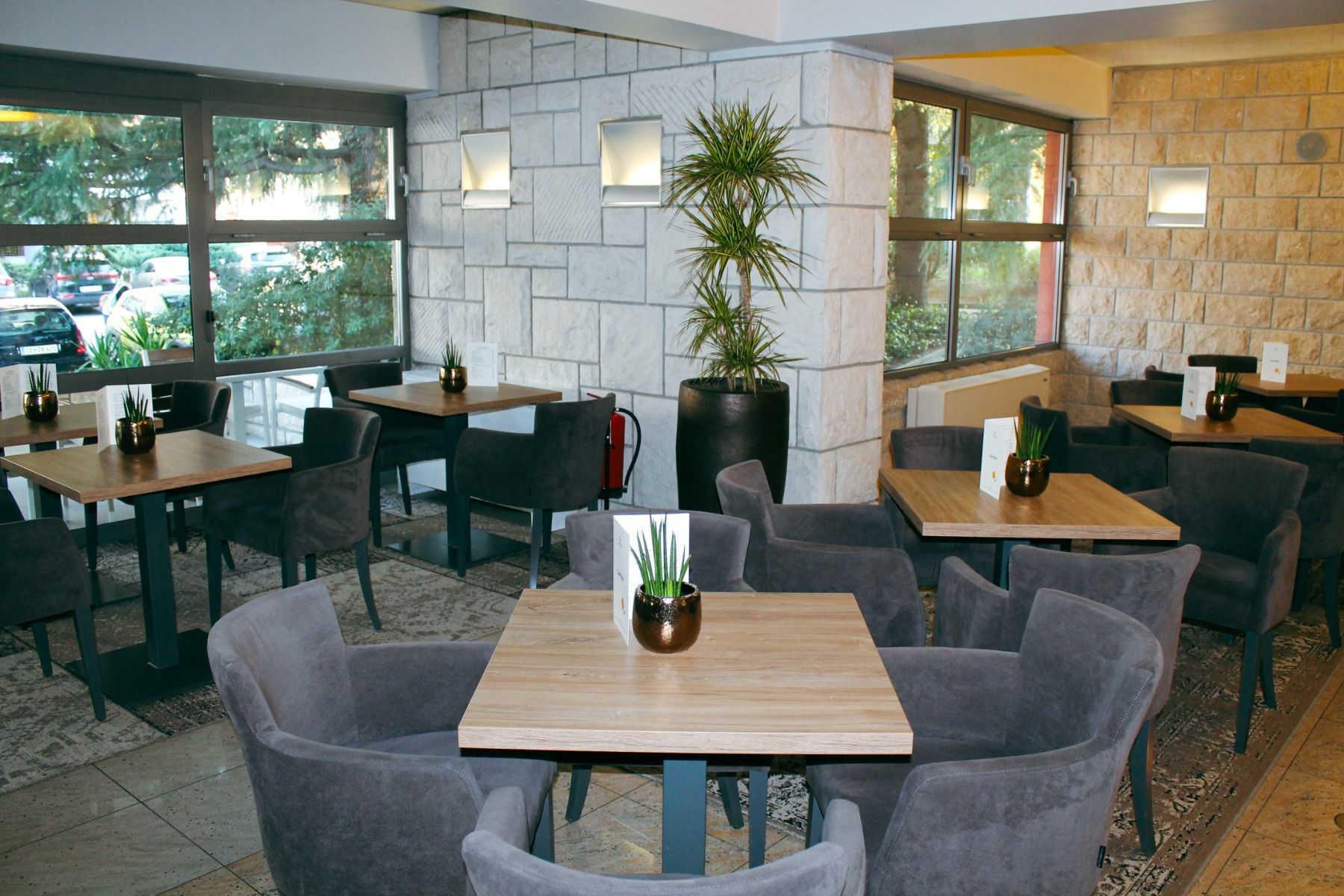 Gemütlicher Innenbereich eines Restaurants mit moderner Einrichtung und Pflanzen.