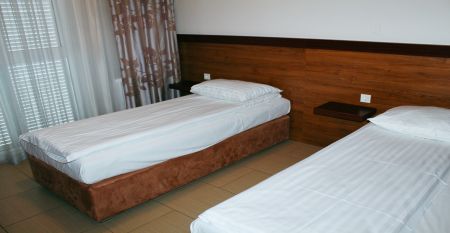Außenansicht des Hotels Aquapark Zusterna mit rosa Fassade, Balkonen und der slowenischen Flagge.