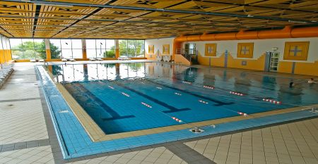 Außenansicht des Hotels Aquapark Zusterna mit rosa Fassade, Balkonen und der slowenischen Flagge.