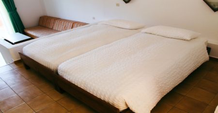 Haupteingang des Giverola Resorts mit Flaggen verschiedener Länder und einem begrünten Umgebung.