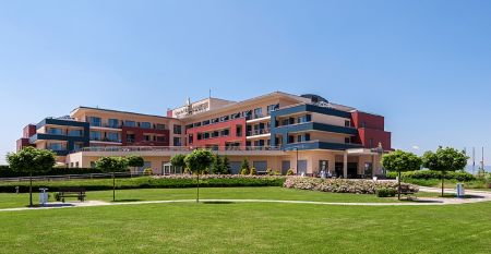 Frontansicht des Grand Hotel Primus Terme Ptuj mit gepflegtem Rasen und Blumen.