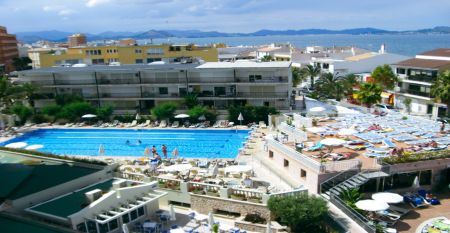 Außenansicht des Hotels Janeiro mit mehrstöckigen Balkonen und gepflegten Pflanzen im Vordergrund.