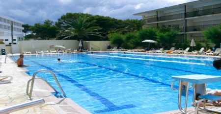 Außenansicht des Hotels Janeiro mit mehrstöckigen Balkonen und gepflegten Pflanzen im Vordergrund.