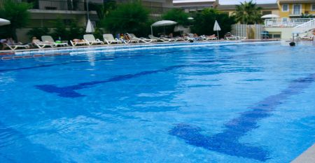 Außenansicht des Hotels Janeiro mit mehrstöckigen Balkonen und gepflegten Pflanzen im Vordergrund.