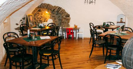 Der Empfangsbereich des Hotels Koruna, mit einer hölzernen Rezeption und einer roten Teppichtreppe, die nach oben führt.
