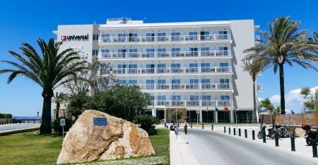 Außenansicht des Hotels Marques mit moderner weißer Fassade, Palmen und gepflegter Gartenanlage.