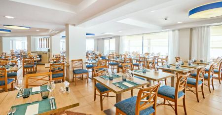 Außenansicht des Hotels Marques mit moderner weißer Fassade, Palmen und gepflegter Gartenanlage.