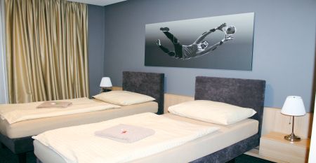 Außenansicht des Hotels OtavArena mit moderner Fassade und Sonnenterrasse.