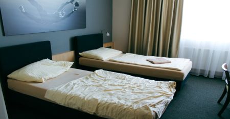 Außenansicht des Hotels OtavArena mit moderner Fassade und Sonnenterrasse.