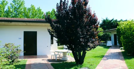 Außenansicht des Hotels Villa Maria mit Balkonen, gepflegtem Garten und mehreren Nationalflaggen vor dem Gebäude