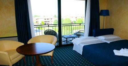 Außenansicht des Hotels Villa Maria mit Balkonen, gepflegtem Garten und mehreren Nationalflaggen vor dem Gebäude