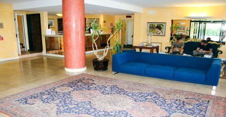 Außenansicht des Hotels Villa Maria mit Balkonen, gepflegtem Garten und mehreren Nationalflaggen vor dem Gebäude