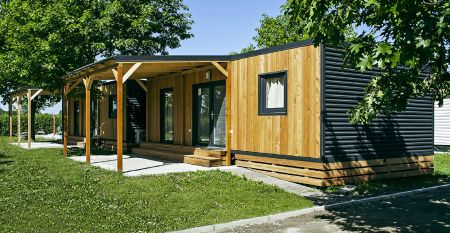 Außenansicht eines modernen Mobilheims mit Holzverkleidung und überdachter Terrasse im Mobile Homes Terme Ptuj.