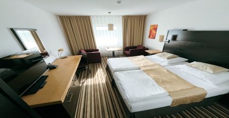 Luftbildaufnahme einer Hotelanlage mit Tennisplätzen, Pool und Parkflächen.