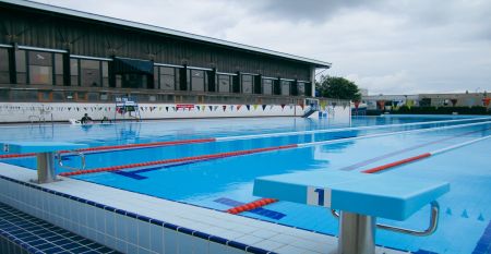 Luftbildaufnahme einer Hotelanlage mit Tennisplätzen, Pool und Parkflächen.