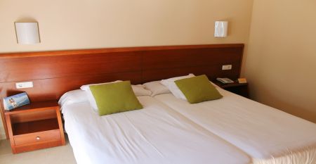 Großzügige Hotellobby mit Holzbalkendecke, bequemen Sofas, Pflanzen und Wanddekoration.