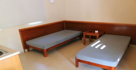 Großzügige Hotellobby mit Holzbalkendecke, bequemen Sofas, Pflanzen und Wanddekoration.