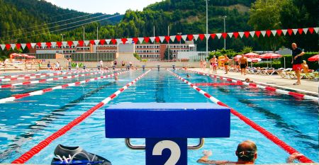 Außenansicht des Sporthotel Kapfenberg mit moderner Fassade und Hotelbeschriftung, im Hintergrund eine Burg auf einem Hügel