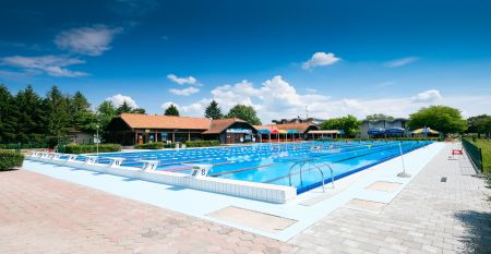 Ein moderner Außenpool mit klaren Bahnen, perfekt für Trainingseinheiten, mit umliegenden Sonnenschirmen.