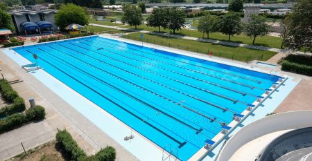 Ein moderner Außenpool mit klaren Bahnen, perfekt für Trainingseinheiten, mit umliegenden Sonnenschirmen.