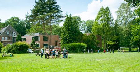 Große Wiese mit spielenden Kindern vor der Jugendherberge Uelzen